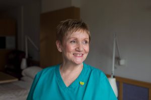 Smiling healthcare assistant in turquoise uniform