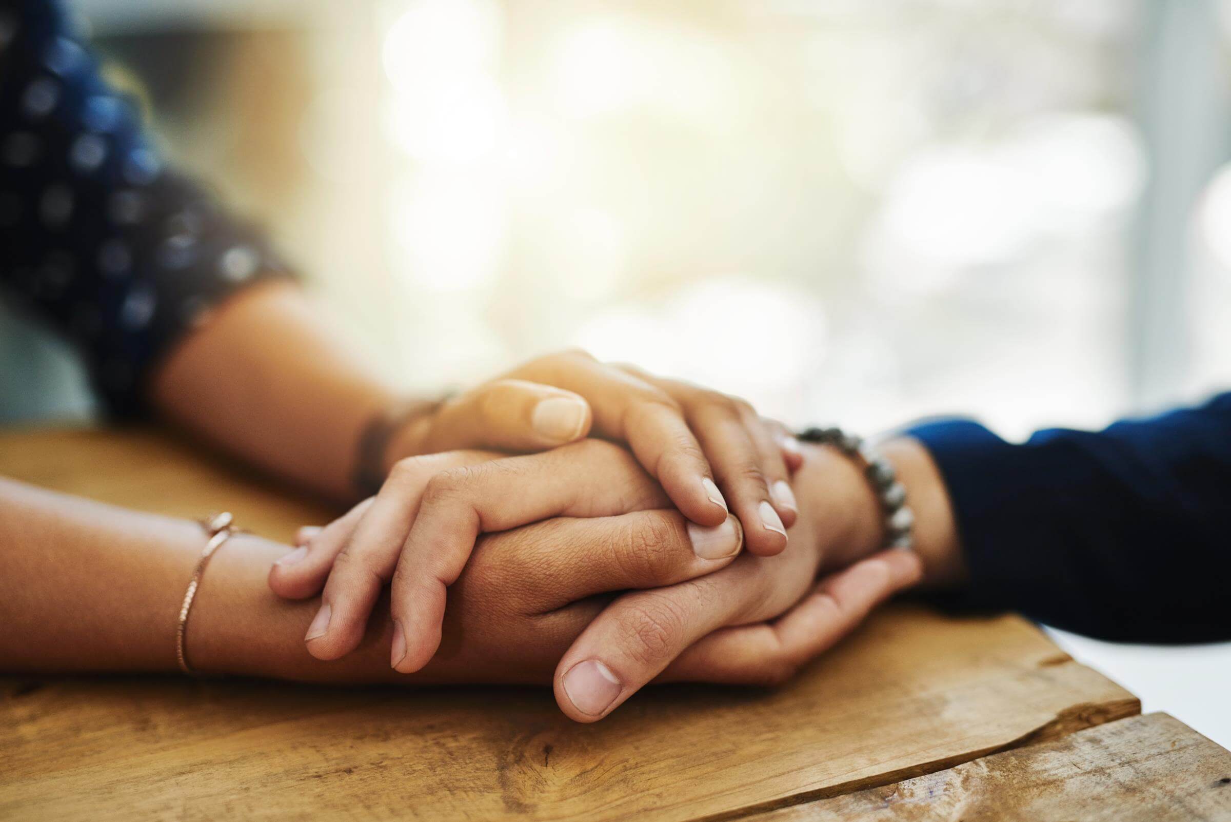 Close up of two people holding hands tighly