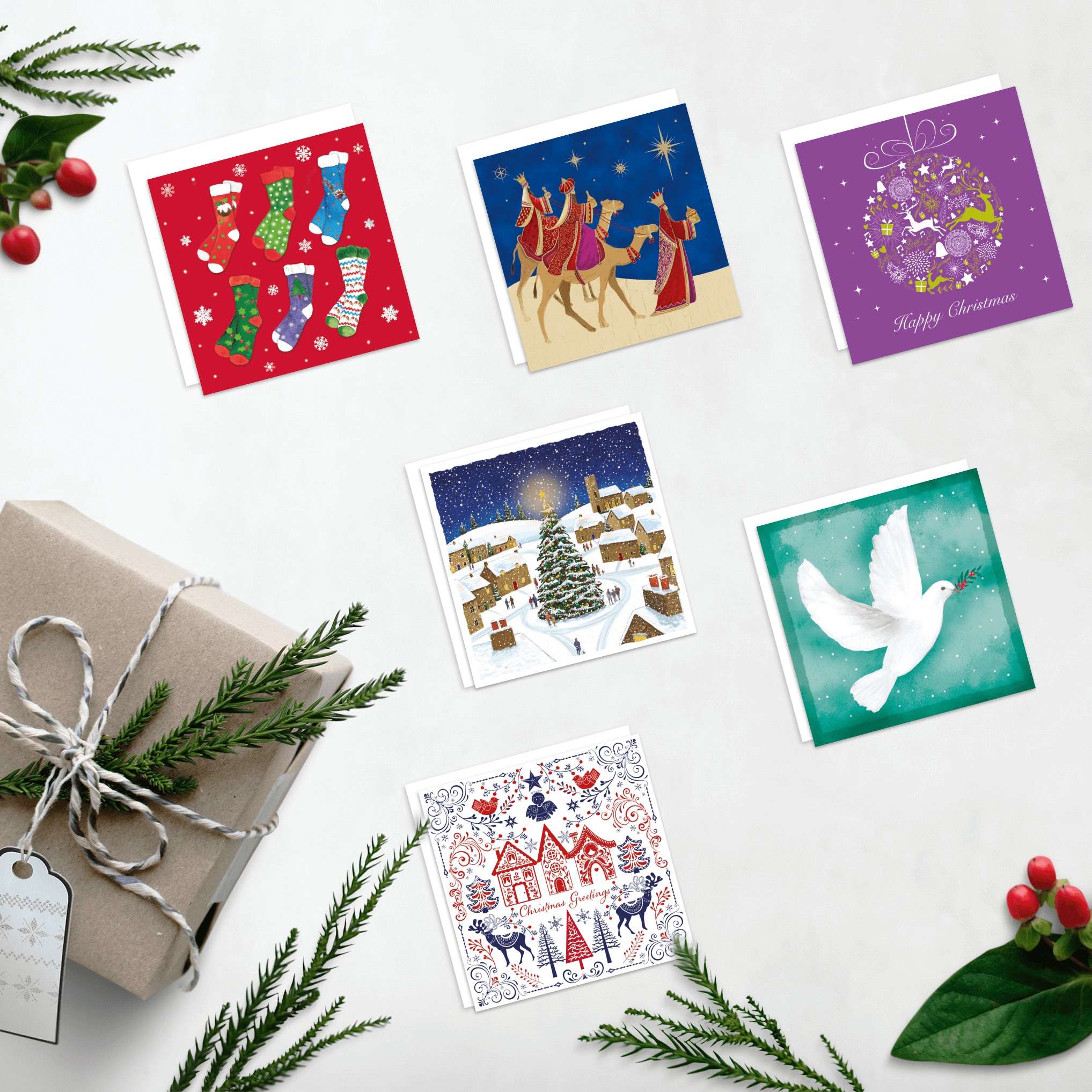 Festive scene with Christmas card designs with a present and greenery