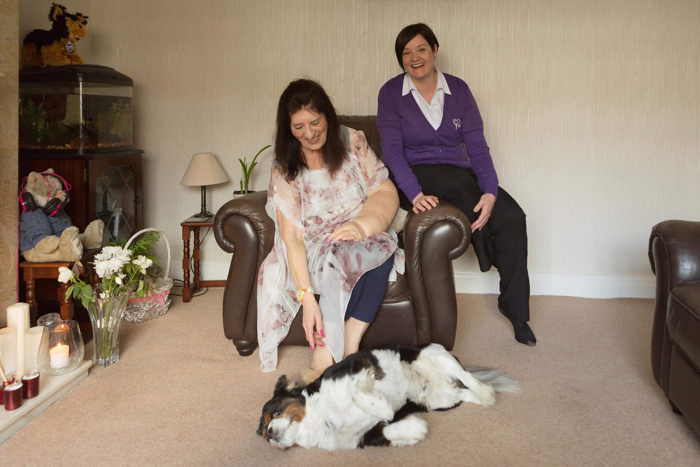 Woman and Community Nurse sitting on armchair in woman's home