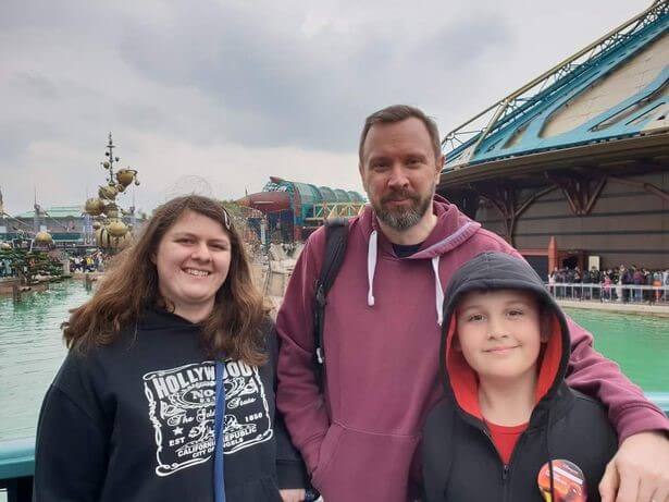 A man and two children at a theme park
